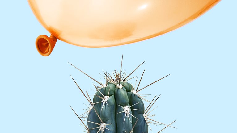 A balloon flying dangerously close to a cactus.