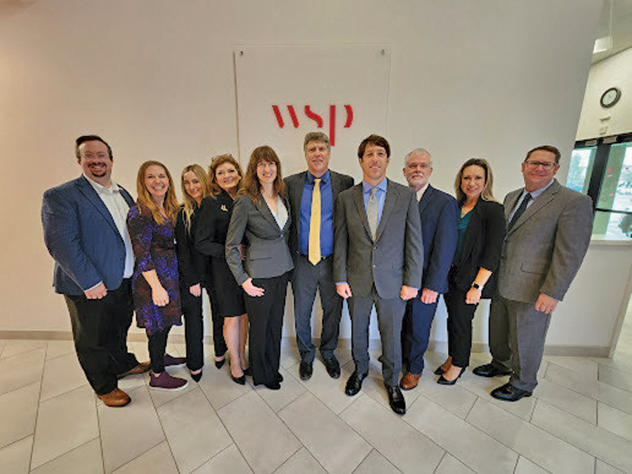 Helmniski Group photo of Helminski's team in front of a WSP banner